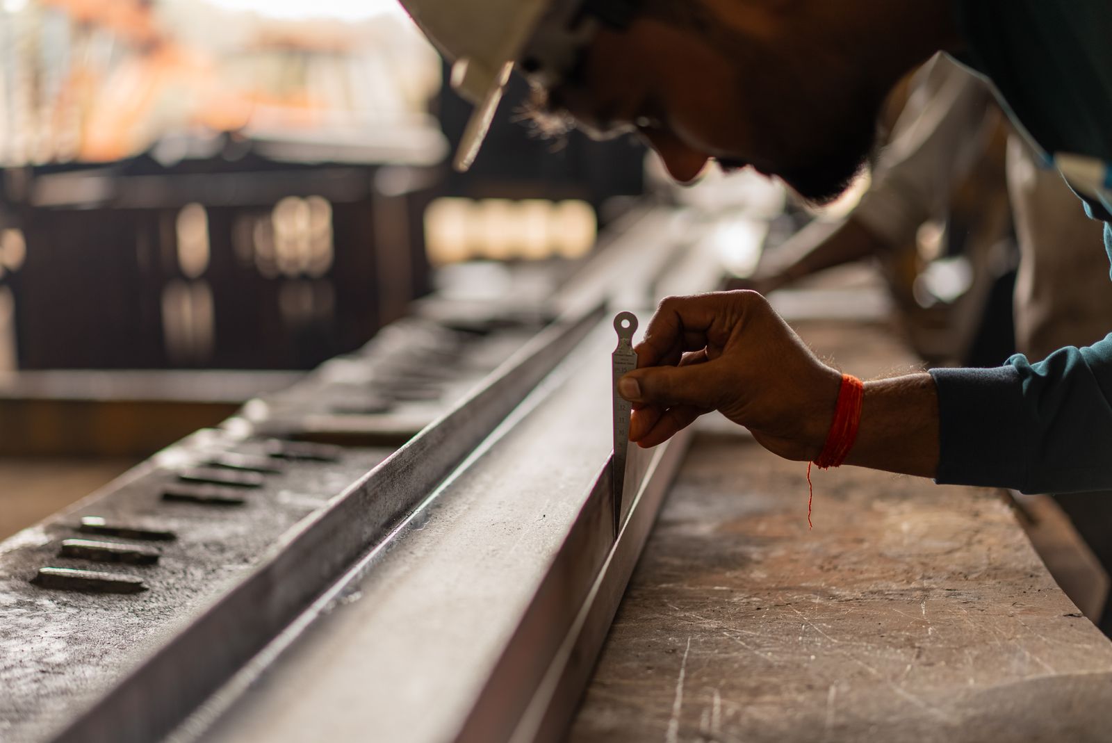inspector checking a metal profile edge with a taper gauge.jpeg