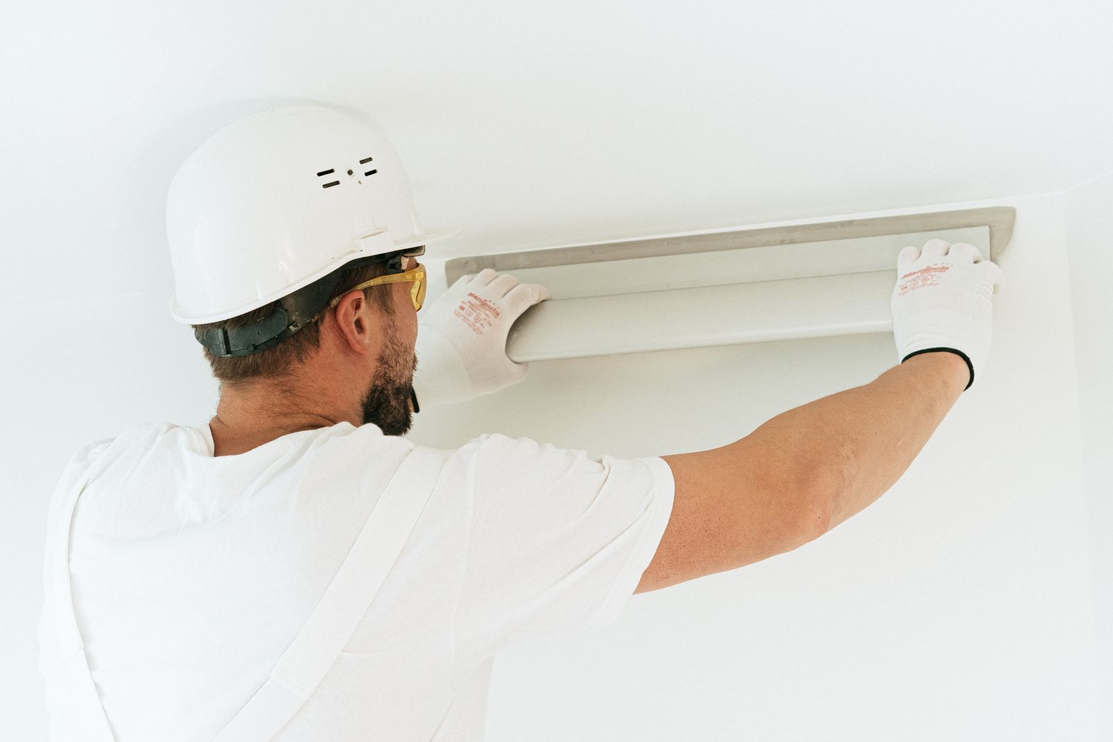 worker fitting a light fixture to the ceiling.jpeg